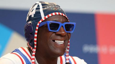 Rapper Flavor Flav wearing an Olympic hat