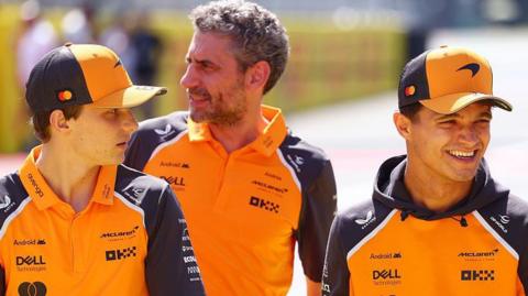 Oscar Piastri and Lando Norris having a conversation after the Italian Grand Prix, with McLaren team boss Andrea Stella stood behind them