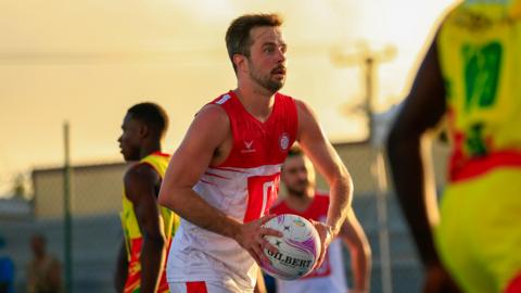 James Thomson-Boston holding a netball during an England match