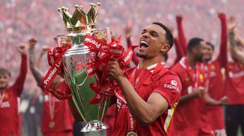 Trent Alexander-Arnold lifts the Premier League trophy on his final Liverpool appearance at Anfield.