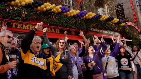 Pittsburgh Steelers and Minnesota Vikings fans cheer outside the Temple Bar pub before their NFL game at in Dublin