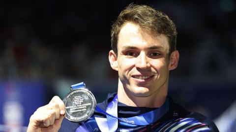 Ben Proud of Great Britain poses with his silver medal 
