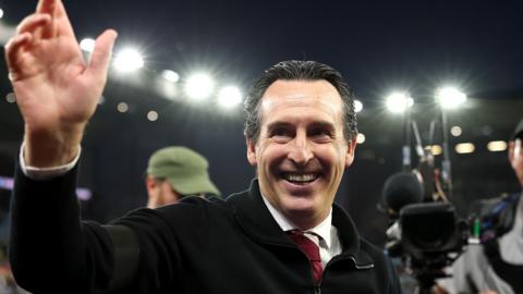 Unai Emery waves while smiling