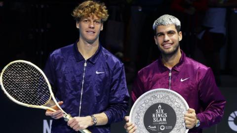 Jannik Sinner and Carlos Alcaraz pose with their trophies following the Six Kings Slam final