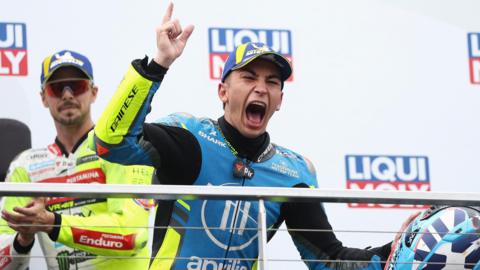 Raul Fernandez celebrates his MotoGP victory on the podium by roaring and pointing his finger 