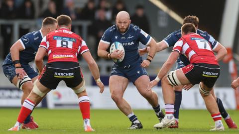 Sale hooker Ethan Caine runs at two Gloucester defenders Will Trenholm (no.8) and Harry Taylor (no.7)