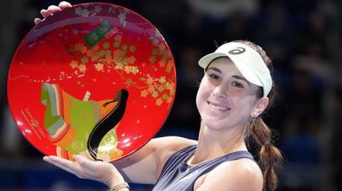 Belinda Bencic of Switzerland poses with the trophy 