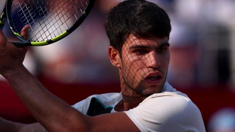 Carlos Alcaraz holding his tennis racquet