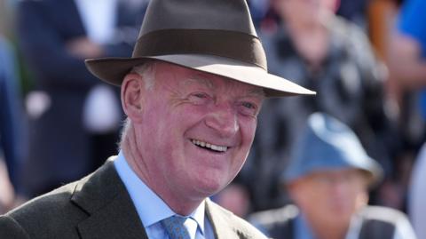 Willie Mullins smiles while wearing a hat