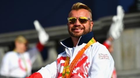 Lee Pearson smiles, with medals around his neck, at the 2016 Paralympics