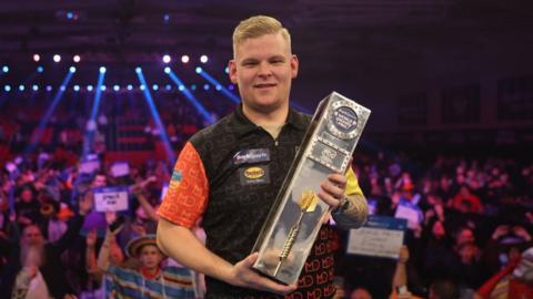 Mike De Decker holding the 2024 Darts World Grand Prix trophy