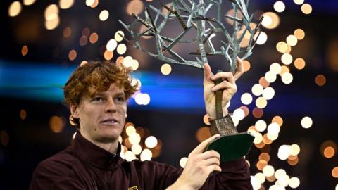 Jannik Sinner lifts the tree-shaped Paris Masters trophy