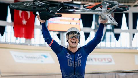 Matthew Richardson holds up his bike after breaking the flying 200m world record