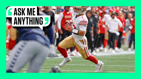 Brock Purdy carries the ball in an NFL game with his feet bent into the ground in a running motion