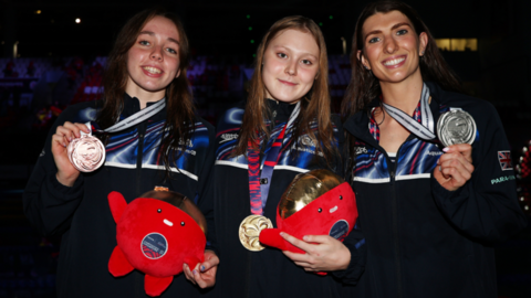 Poppy Maskill (centre), Bethany Firth (right) and Georgia Sheffield with their medals from an all-British top three in the women's S14 100m backstroke event at the World Para Swimming Championships in Singapore